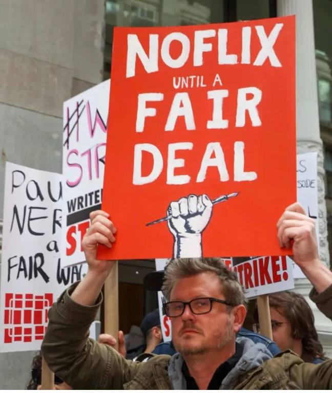 美国人真的开始害怕AI了，好莱坞最著名的剧作家们冲上街头，堵在 Netflix、迪士尼、派拉蒙和亚马逊公司门口，这是好莱坞15年来唯一一次罢工运动，也是人类第一次因为AI大规模罢工抗议